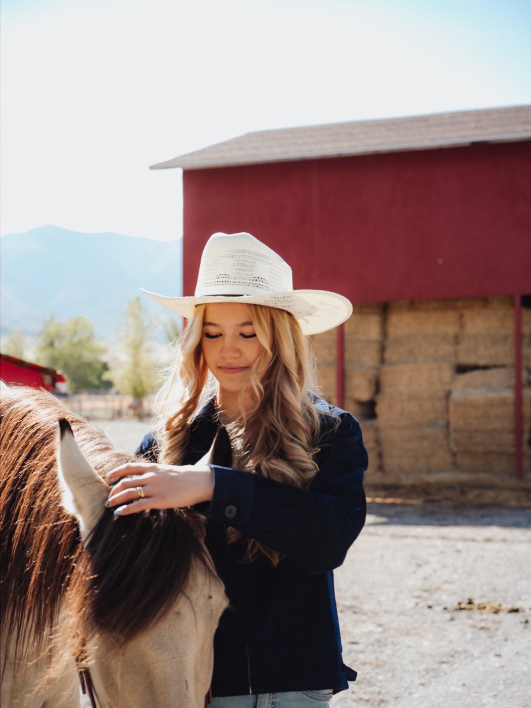 Kennedy with her horse by the red hay barn